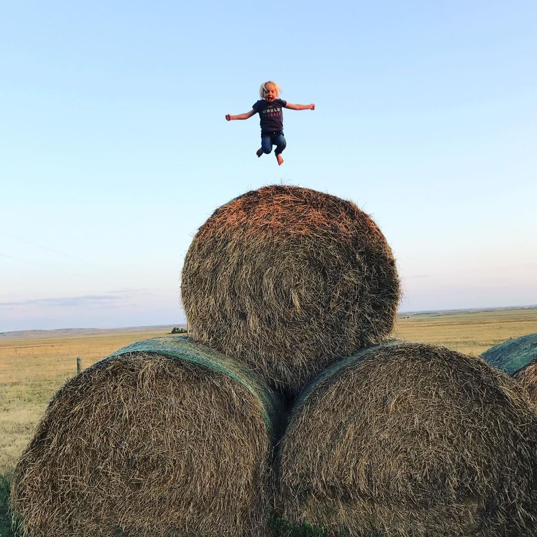 Kid jumping on Hay