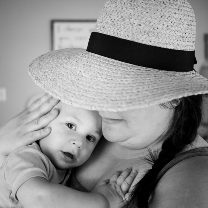 woman in hat holds baby